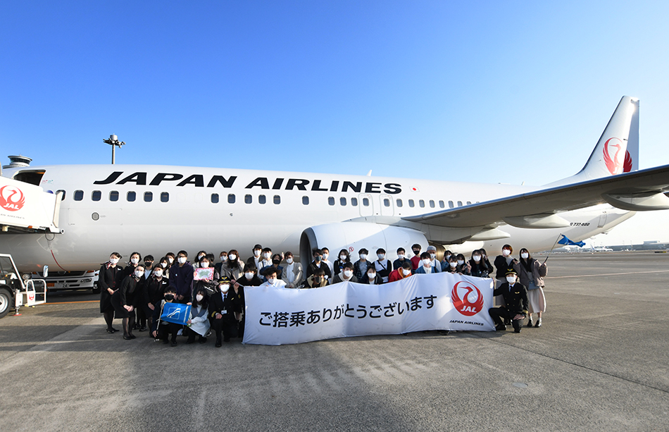 搭乗したB737型機をバックに、クルーを囲んで記念撮影